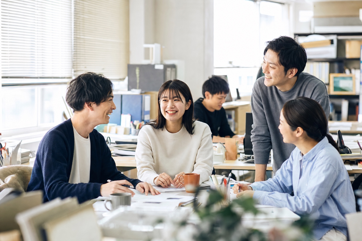 資料を囲んで笑顔で話すチームメンバー