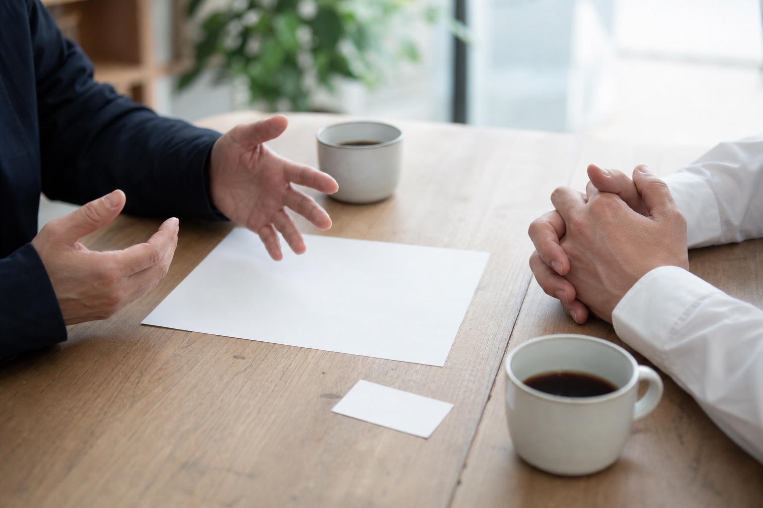 資料を挟んで商談する二人の手元